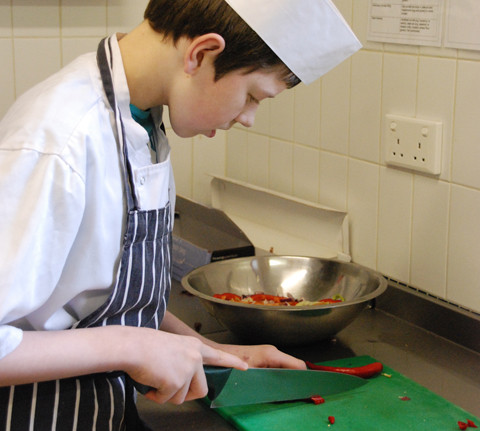 Catering student Michael Langley preparing food  for the Come Dine With Us event
